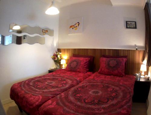 Un dormitorio con una gran cama roja con almohadas rojas en Imagine My B&B en Róterdam