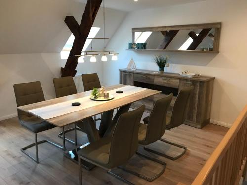 a dining room with a wooden table and chairs at Haus-Hafenblick in Lassan