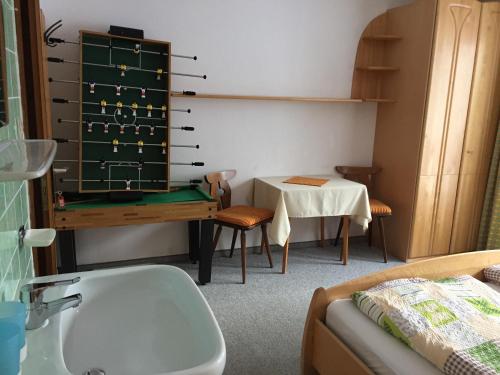 Zimmer mit einem Schreibtisch, einem Tisch und einem Tisch in der Unterkunft Haus Holaus in Aschau