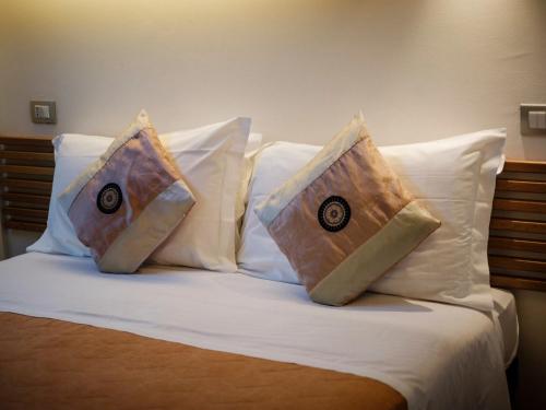 a bed with two pillows on top of it at Hotel Villa Lalla in Rimini