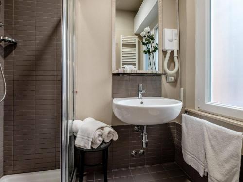 un piccolo bagno con lavandino e specchio di Hotel Villa Lalla a Rimini