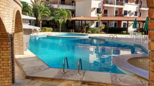 une piscine à l'eau bleue dans un immeuble dans l'établissement FLAT VILA DO MAR, à Aquiraz