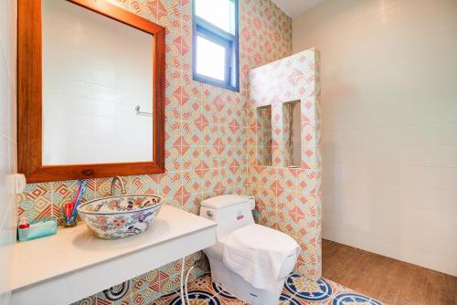 a bathroom with a sink and a mirror and a toilet at Baan Patcharintorn Samui in Chaweng