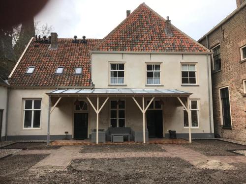 a white house with an awning on the front at Bed & Breakfast Huis Sevenaer in Zevenaar