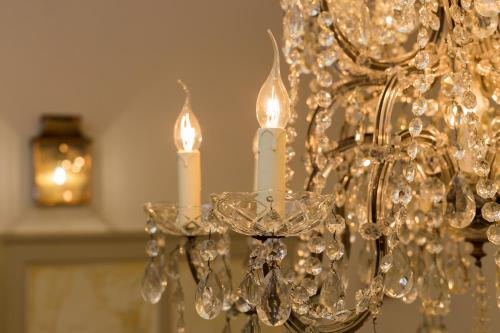 a chandelier with two white candles on it at Bed & Breakfast Huis Sevenaer in Zevenaar