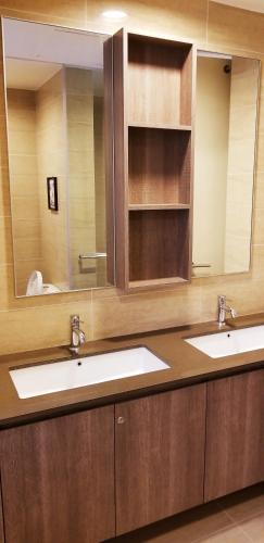 un bagno con due lavandini e un grande specchio di By The Sea Beach Luxury Resort - Batu Ferringhi a Batu Ferringhi