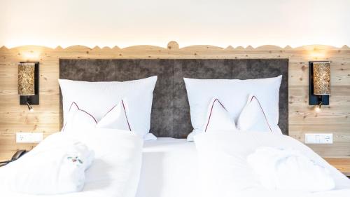 a bedroom with two white pillows on a bed at Hotel Trattlerhof in Bad Kleinkirchheim