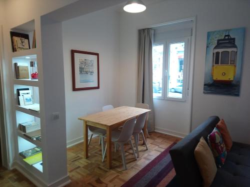 a dining room with a table and chairs and a window at Alex Home in Lisbon