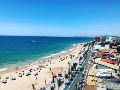 a beach with a lot of people and the ocean at Hotel Brisa Tropical De Macaé in Macaé