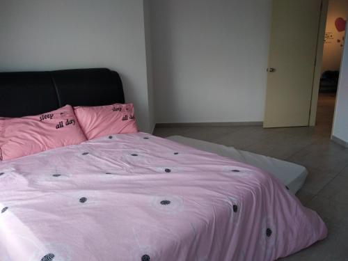 a pink bed with pink sheets in a bedroom at Atlantis Residence Melaka in Melaka