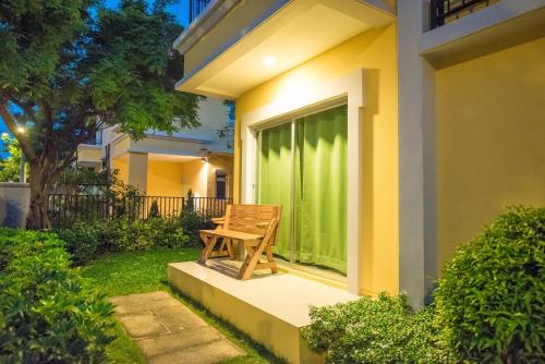 a wooden bench sitting on the porch of a house at Munlihouse Cha-Am Hua-Hin Beach in Cha Am