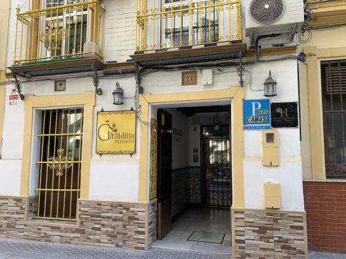 una entrada a un edificio con un cartel en Giraldilla, en Sevilla