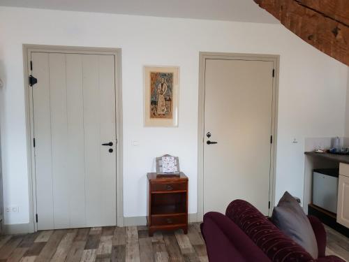 a living room with two doors and a couch at Bed & Breakfast Huis Sevenaer in Zevenaar
