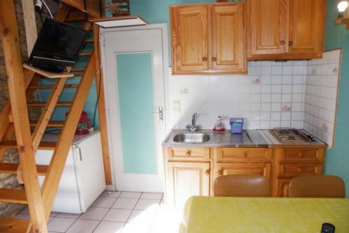 - une cuisine avec un évier et un escalier dans la chambre dans l'établissement Petite location de vacances en Bretagne sud, à Névez