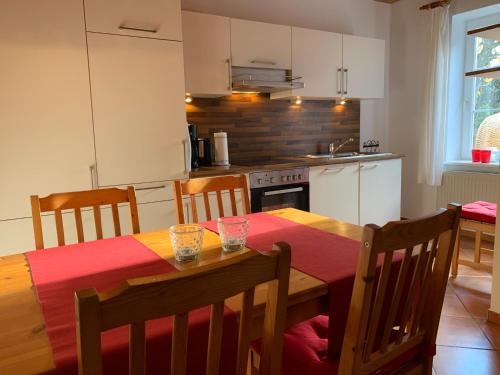 a kitchen with a wooden table with chairs and a dining room at Ferienhof Utech in Wenkendorf auf Fehmarn