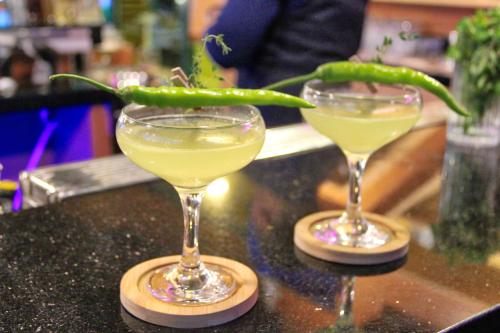 two glasses sitting on a counter with a green drink at New Dawn Hotel Plus in Cagayan de Oro