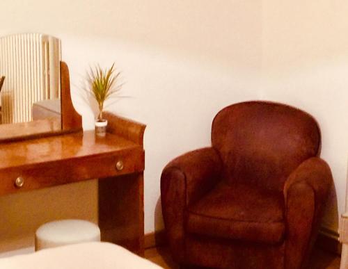 a brown chair sitting next to a wooden desk at Le 3 fuscien in Amiens