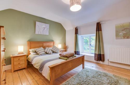 a bedroom with a large bed and a window at 2 Tan-y-castell in Dolwyddelan