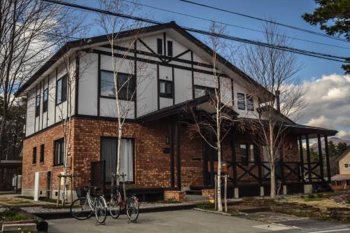 a house with bikes parked in front of it at Hakuba Powder Lodge Taketombo in Hakuba