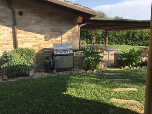 a barbecue in a yard next to a brick house at La Villa degli Ulivi in Fermo