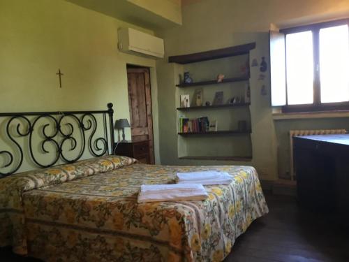 a bedroom with a bed and a cross on the wall at La Villa degli Ulivi in Fermo