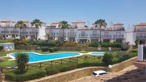 un complexe avec une piscine en face d'un bâtiment dans l'établissement Las Lomas de Cabopino, à Marbella