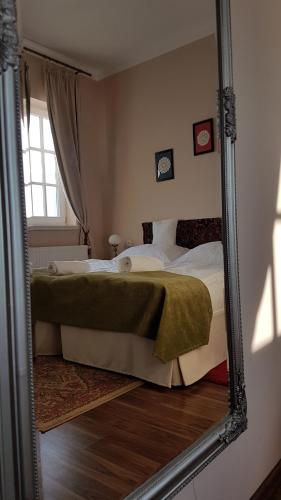 a mirror reflection of a bed in a bedroom at Tarnóca Kúria in Soponya