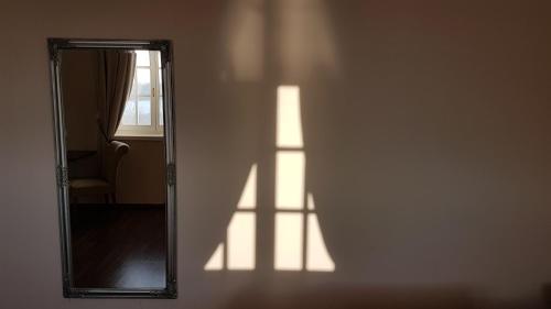 a shadow of a mirror on a wall at Tarnóca Kúria in Soponya