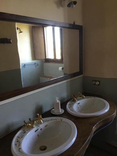 a bathroom with two sinks and a large mirror at La Villa degli Ulivi in Fermo