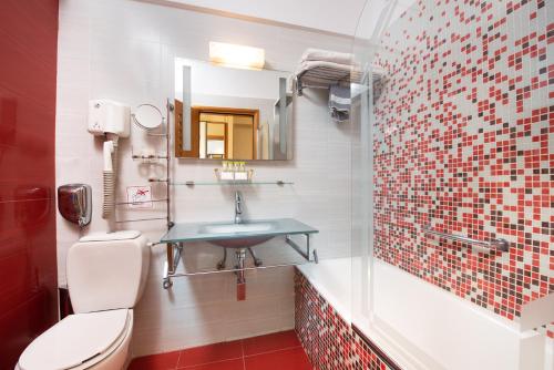 a bathroom with a toilet and a sink at Heliotrope Hotels in Mytilini