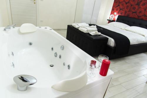 baño con bañera blanca junto a la cama en Essential Suite B&B Botanic en Nápoles