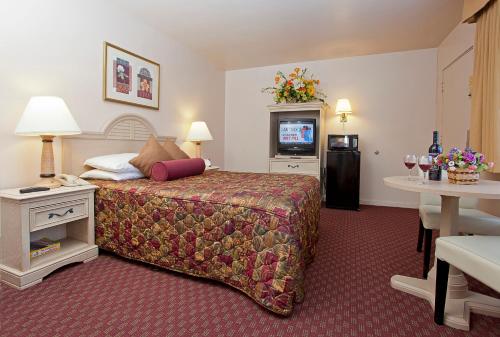 a hotel room with a bed and a television at El Camino Inn in Daly City