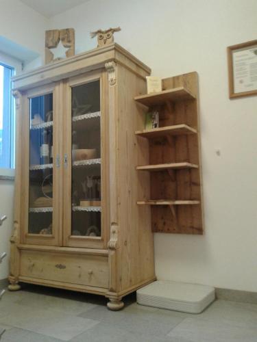 a wooden cabinet in a room with shelves at Schweinberger Sixtus in Aschau