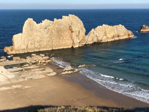 an aerial view of a beach with rocks in the ocean at Apartamento Ria de Boo, Con patio privado in Boó de Piélagos