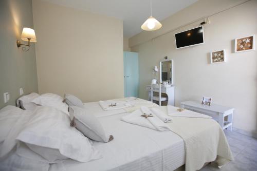 a bedroom with a white bed with towels on it at Alexandra's Rooms in Parikia