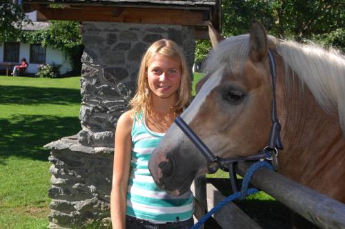 a young girl standing next to a horse at Hotel Garni Ransburgerhof in Flachau