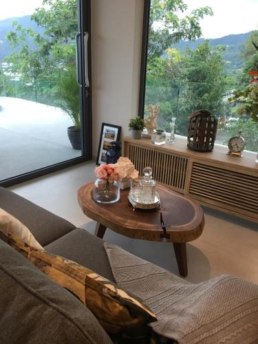 a living room with a coffee table and a large window at Patong Heights in Patong Beach