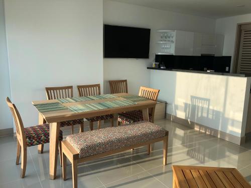 卡塔赫納的住宿－Excelente Apartamento en Murano Elite en Bocagrande, Cartagena，一间带木桌和椅子的用餐室