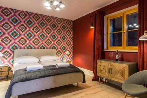 a bedroom with a bed and a red wall at udanypobyt Dom Hillside in Gliczarów