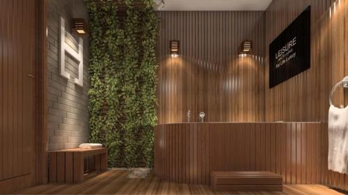 a bathroom with a green wall with a bath tub at Romance Alexandria Hotel in Alexandria