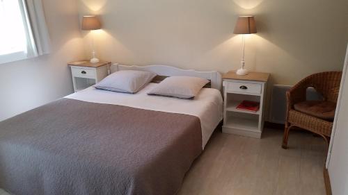 - une chambre avec un lit, 2 tables de chevet et une chaise dans l'établissement Chambres d'Hôtes Côté Campagne, à Vaux-sur-Aure