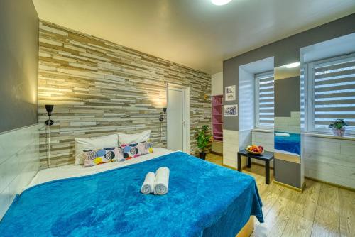 a bedroom with a blue bed and a brick wall at Fox Rooms Aparthotel in Stara Zagora