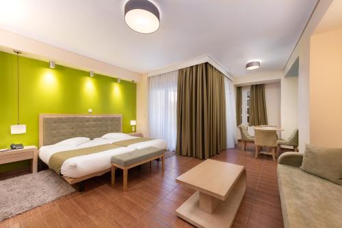 a bedroom with a large bed and a green wall at Heliotrope Hotels in Mytilini