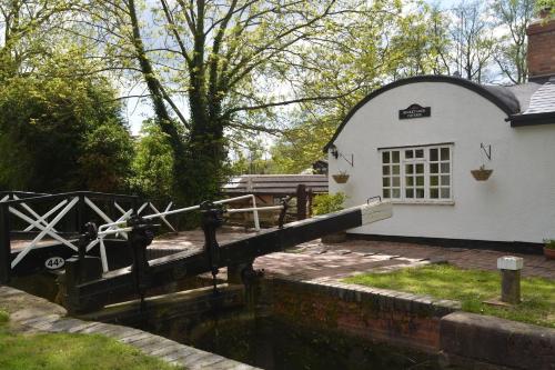 a house with a canal in front of it at Bucket Lock Cottage in Warwick