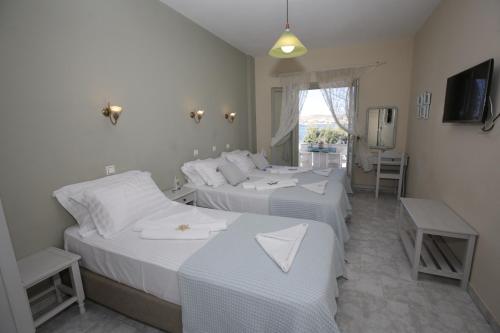 a bedroom with two beds and a television in it at Alexandra's Rooms in Parikia