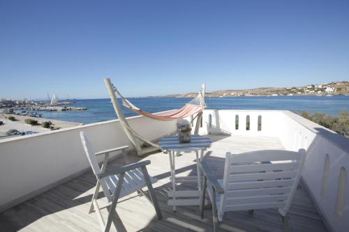 a table and chairs on a balcony with the ocean at Alexandra's Rooms in Parikia