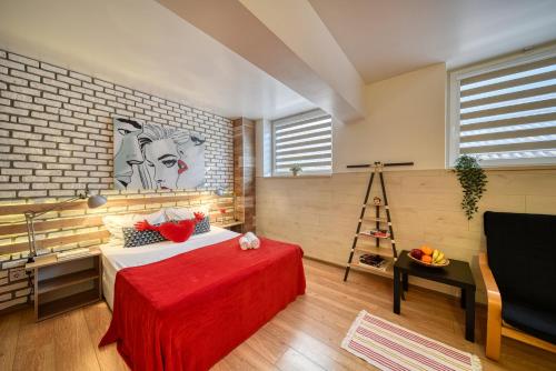 a bedroom with a bed with a red blanket at Fox Rooms Aparthotel in Stara Zagora