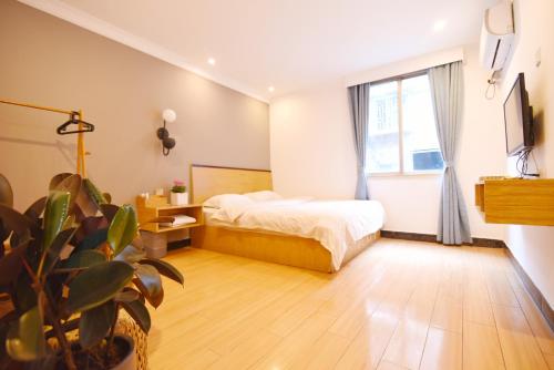 a bedroom with a bed and a large window at Guilin Cyan Box Guest House in Guilin