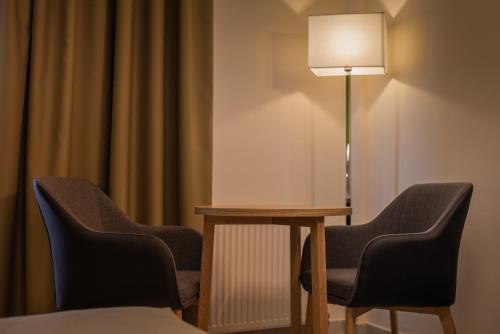 a room with two chairs and a table with a lamp at Heliotrope Hotels in Mytilini