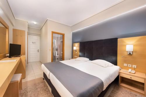 a bedroom with a large bed and a television at Heliotrope Hotels in Mytilini